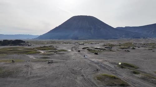 Arid Desert Landscape with Mountains and Vehicles