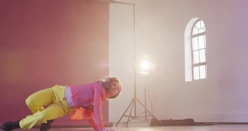 Happy caucasian female dancer dancing alone in dance studio, slow motion