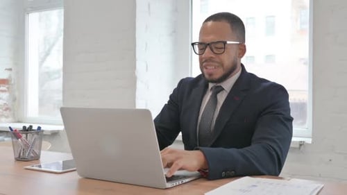 Man Working on Laptop in Bright Office