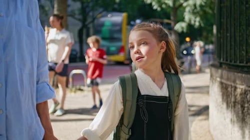 Nahaufnahme Schulmädchen schlendert Mama in der Sunny Street Walking Kind Sprechendes Elternteil