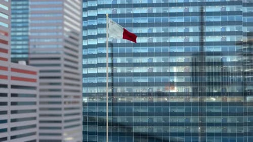 Maltese Flag Waving on Modern Skyscraper