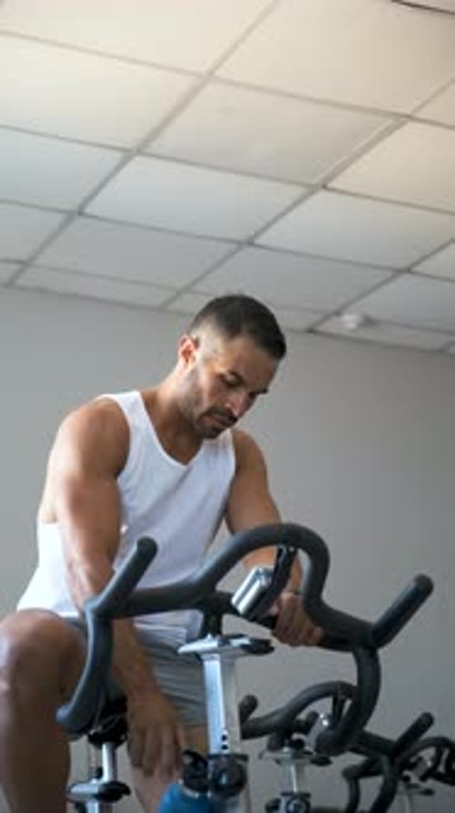 Strong Latin Man Doing Spinning Cycling at a Gym