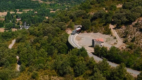 Vista aérea do túnel de saída do trem de passageiros na paisagem da floresta montanhosa