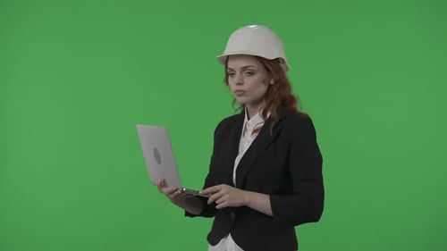 A Woman Architect Works on a Laptop Studies Plans Prints Reports Business Woman in a Protective