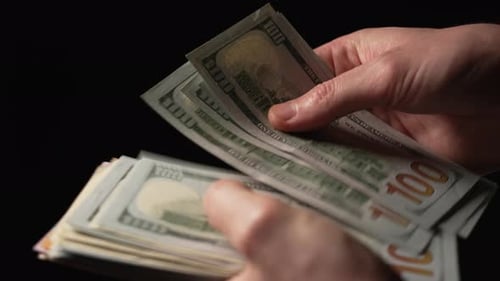 Male hands close-up counting US currency and handing money