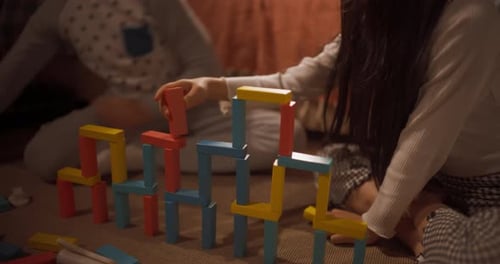 Portrait of Two Children Playing in their Room Using Construction Building Blocks. Active K