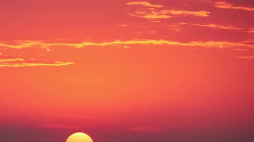 A big red sun in the dawn sky, a hot summer landscape. Morning sky in bright sunlight