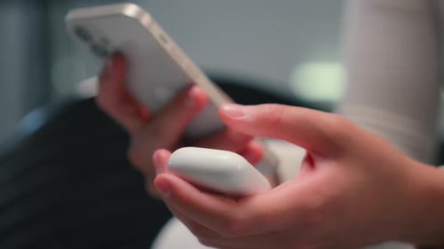 Hands Holding Phone and Wireless Earbuds Case