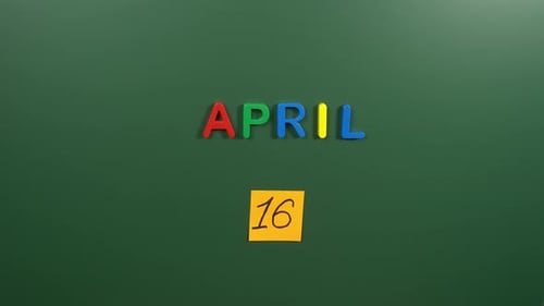 Hand sticking a sticker 16 April calendar day on school board. 16 date of April. Sixteenth day