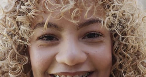 Close-up of a young biracial woman smiling at the camera