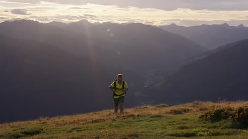 Man In Yellow Shirt Hiking With Silhouetted Mountain View