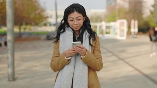 Woman Celebrates Good News on Mobile Phone in City