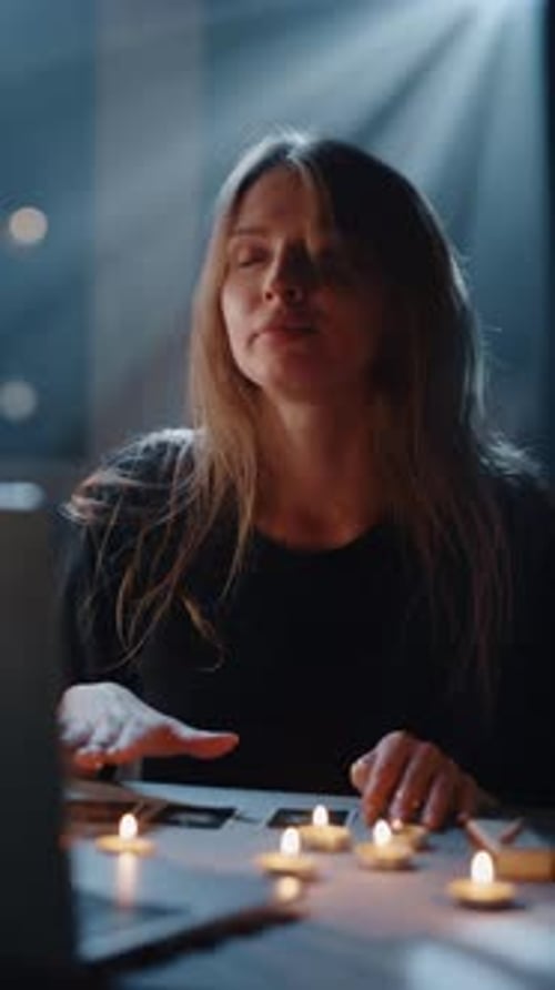 Young Woman Performing Tarot Reading Ritual with Candles Indoors