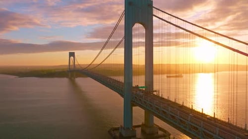 Calm waters of East River at setting sun. Beautiful construction of Whitestone bridge