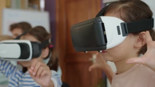 Little Girls in VR Glasses Studying at Group Class at School