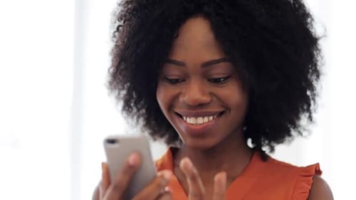 Smiling Woman Using Phone Indoors