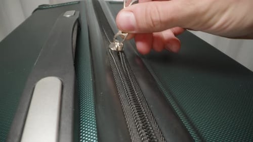 A Close-up of a hand locking the suitcase zippers in place, providing added security for the journey