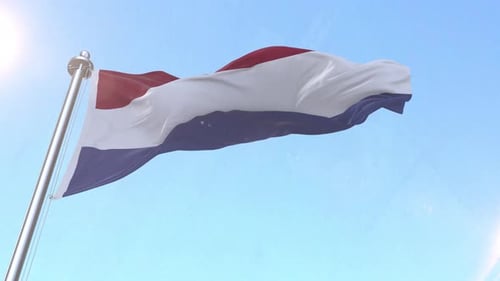 Waving Flag of the Netherlands Against Blue Sky