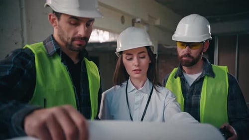 Kaukasische Männer, Frauen, Arbeiter, Kollegen diskutieren über ein Bauplan-Baupapierprojekt