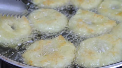 A kuih keria está sendo frita com óleo de cozinha em uma panela quente. É um bolo malaio tradicional. Feito de