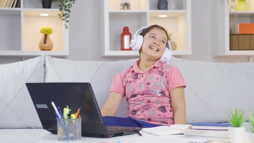 Happy Girl Listening and Singing with Laptop at Home