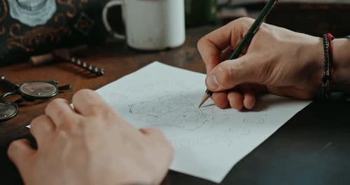 Person Sketching Skull Design on Paper