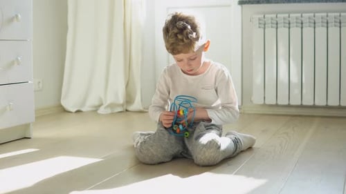 Little Boy Playing Education Logical Toy on the Floor in Nursery