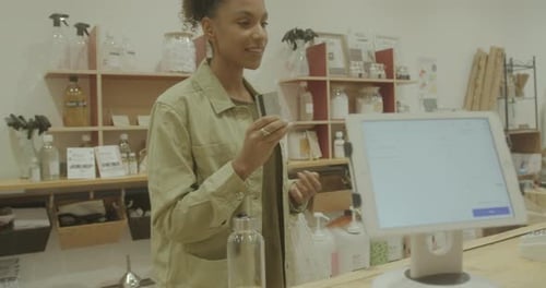 Female in Store paying with Credit Card at Till for Purchase