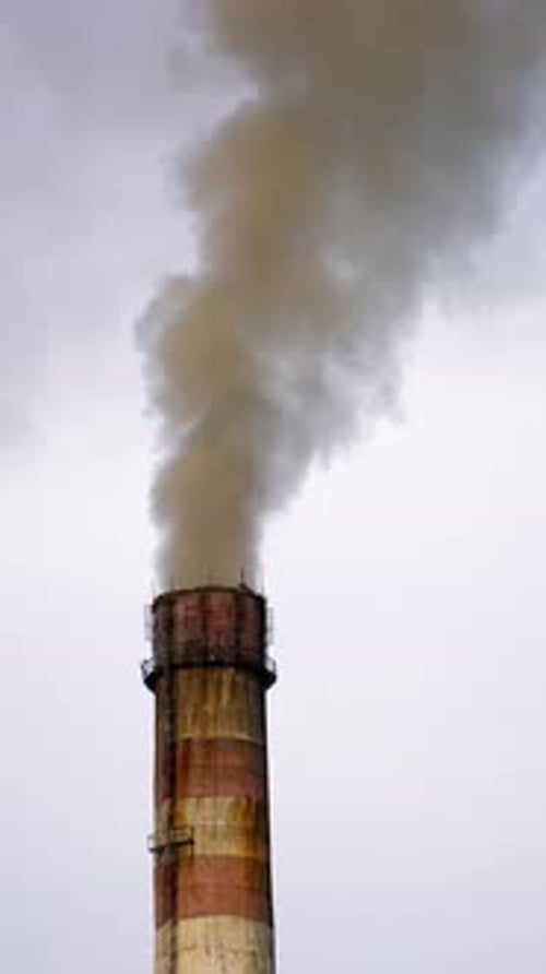 Industrial Chimney Emitting Smoke Against Cloudy Sky