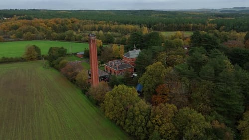High Resolution Aerial Drone Footage of Historic Pumping Station Among Autumn Trees in Nottingham UK