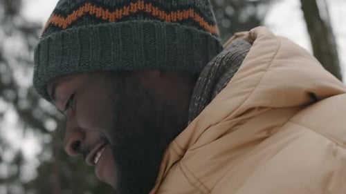 Young Dad Pulling Teen Daughter on Sled while Walking in Winter Forest