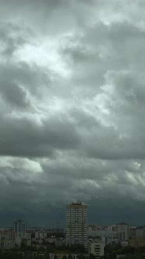 Vertical Timelapse of Heavy Gray Cumulus Clouds Quickly Running Over City