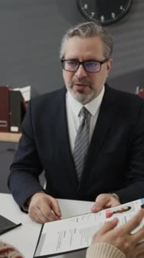 Personnel Manager Giving Resume Back to Young Applicant Asking Him to Sign It