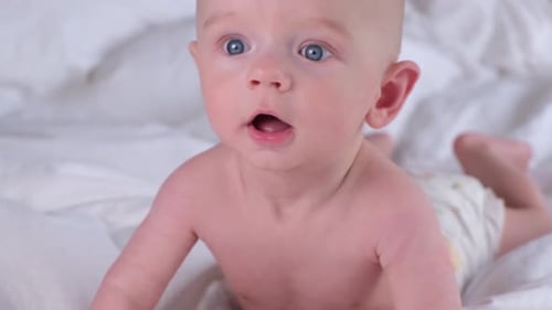Cute Baby Lying on White Blanket Close Up