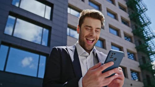 Overjoyed Businessman Looking Cellphone Reacting on Great News at Street Closeup