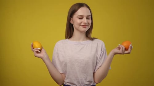 Young Woman Holding an Orange and Lemon