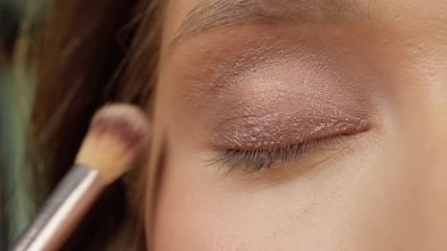 Woman Applies Eyeshadow with Brush Close Up