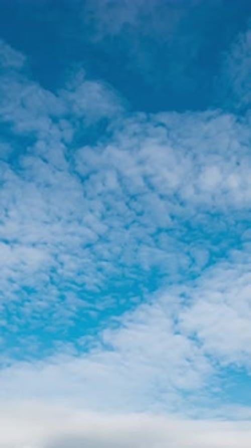 Wunderschöner Sommertagshimmel mit flauschigen weißen Wolken im Zeitraffer in hellblauer Atmosphäre.