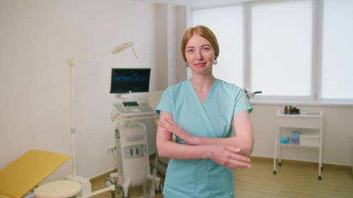 smiling gynecologist doctor in gynecological office near ultrasound and gynecological chair waiting