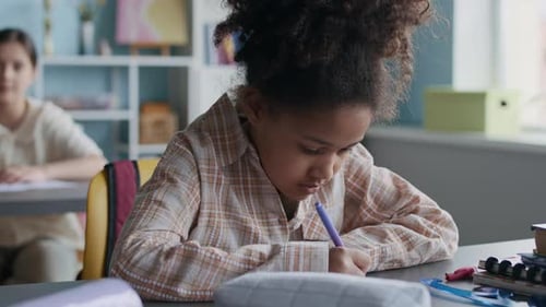 Child Writing at School Desk Close Up