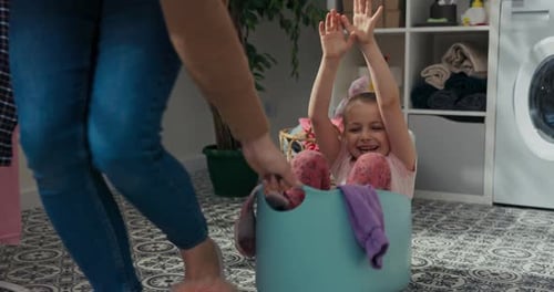 Happy Child Rides in Laundry Basket