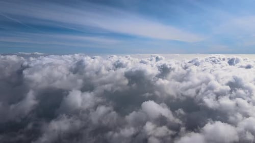 Aerial View From Airplane Window at High Altitude of Earth Covered with White Puffy Cumulus Clouds