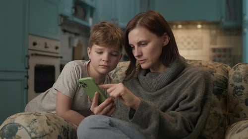 Mother and Child Using a Mobile Phone at Home