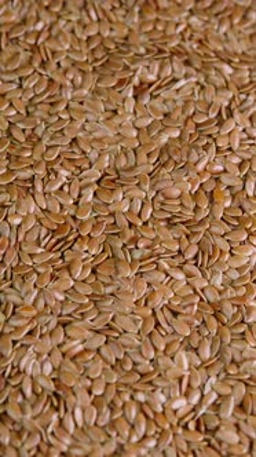 Vertical video flax seeds rotating top view close up. Linseed rotate. Healthy nutrition, dieting