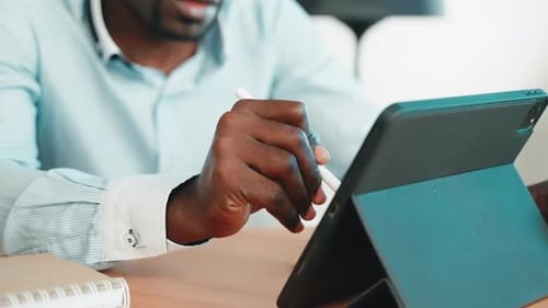 Man Uses Stylus on Tablet Device in Office