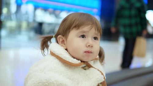 Cute Little Girl Looking Around While Munching Food At The Shopping Mall. closeup, slowmo