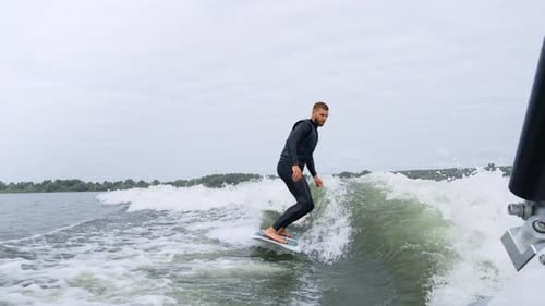 Surfer Skillfully Rides a Wave Showcasing Balance and Agility on the Water Surface