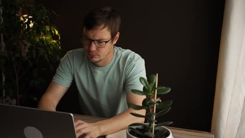 Tired Freelancer Rubbing Eyes and Taking Off Glasses at Home Office Desk