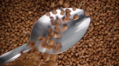 Spoon Filling Up with Buckwheat Grains