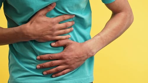 Man Holds Stomach, Indicating Pain or Digestive Issues